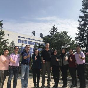 A group of people posed outside giving 'thumbs-up'.