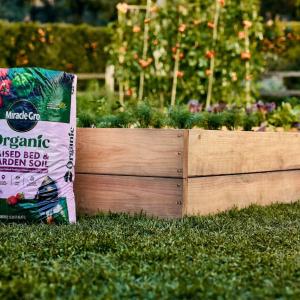 Bag of Miracle-Gro Raised Bed & Garden Soil leaning against a raised bed