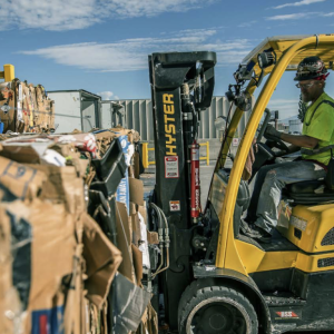 forklift working in an outdoor field of recovered cardboard