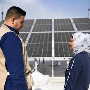 Action Against Hunger's Abdul Kareem, 28, works on a solar electricity project with Amira, the manager of a local school in Aleppo.