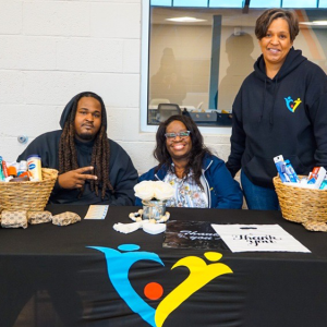 3 People behind a table at the fair