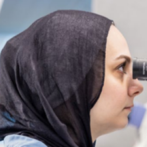 A person looking in a microscope.