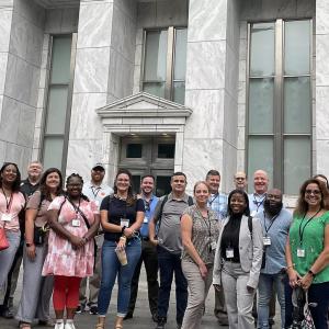 a large group outside a stone block building