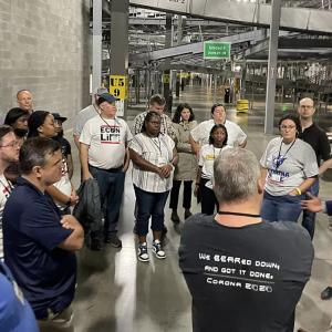 a large group of people on a tour of a UPS facility