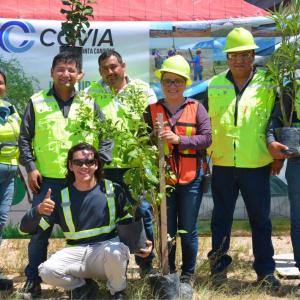 Abel and other teammates holding tree saplings.