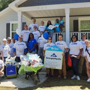 team standing in front of house