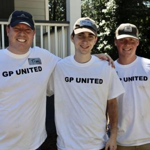 team standing in front of house