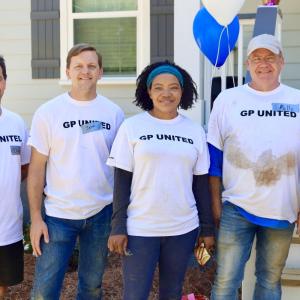 team standing in front of house