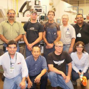 Team of employees posed in a warehouse setting.