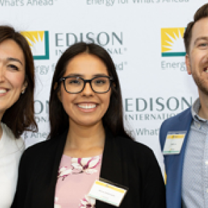 Three people posed in front of an Edison backdrop.
