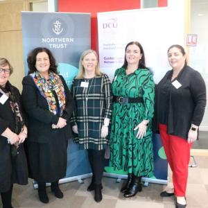 Five people posed in front of a Northern Trust banner.