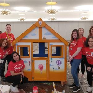 A group surrounding a finished playhouse.