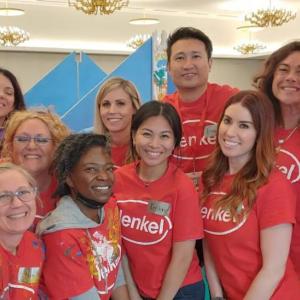 A group of people huddled for the photo. Wearing matching Henkel t-shirts.