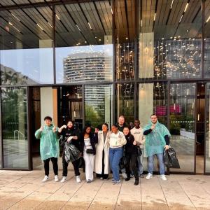A group posed outside a building. Some giving thumbs-up.