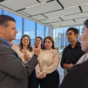 Person speaking to a small group in an office setting.