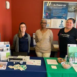 Three people standing behind a display table.