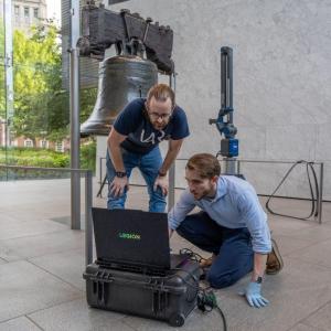 two people working next to the liberty bell