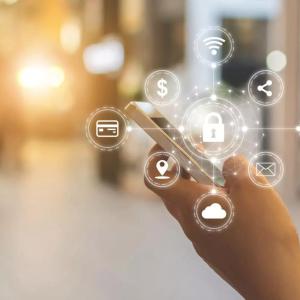 A hand holding a cell phone. Digital icons on top, A key lock is central surrounded by other icons for wifi, share, contacts, email, cloud, location, credit card, and money.