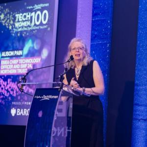 Alison Pain speaking at a purple dais