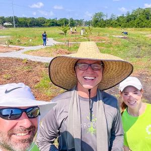 Three people stood together smiling 