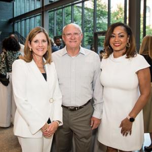 Three people dressed in white at the museum opening.