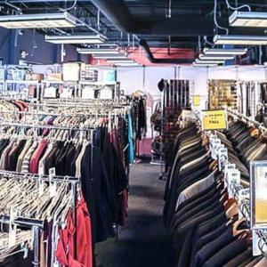 Many racks of clothing in a room.