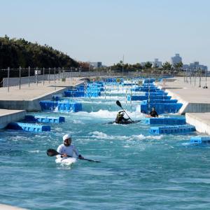 man-made whitewater kayak river, people kayaking don it and some walking along side on the cement walkway