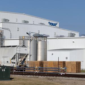 A large industrial plant with train car in front and "Toray" sign on the side.