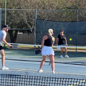 Four people playing pickleball