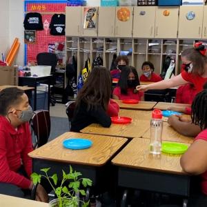 Cossey passes out samples from the garden to her students. 