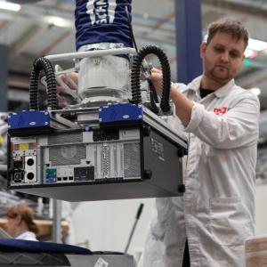 A person using machinery to lift a computer tower.