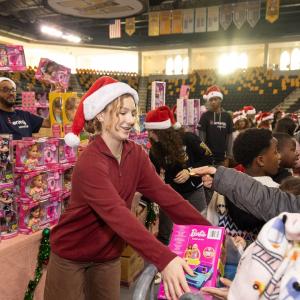A volunteer handing out toys to others