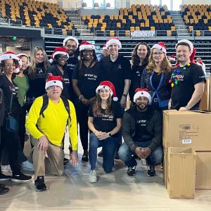 A group of posed volunteers in santa hats.