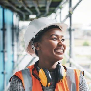 smiling tradeswoman wearing orange vest and hard had