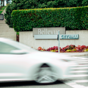 Cars going by on a street in front of a sign "Bellevue"