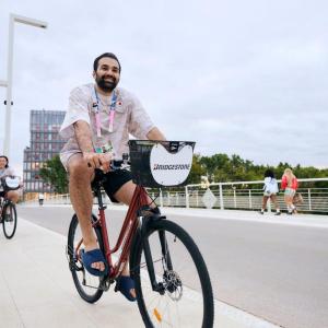Smiling people riding bicycles on a road.