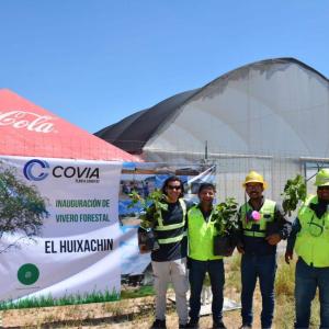 Abel and other teammates holding tree saplings.