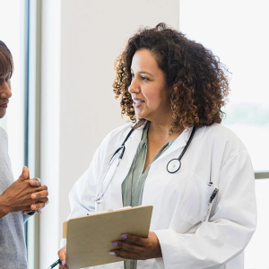 A woman in a lab coat asking questions to a woman