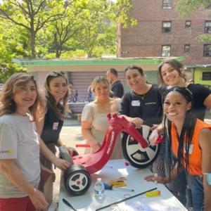 a group of people outside working on a tricycle