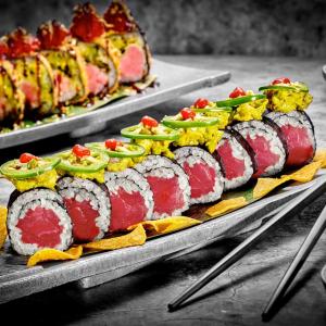 Two trays of precisely arranged sushi rolls.