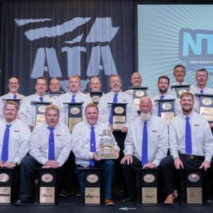 A group posed with awards