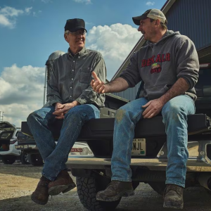 2 farmers talk on a truck bed