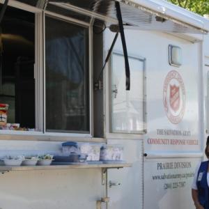 Debbie Clarke standing next to the CRU truck,  wearing a blue vest