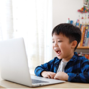 boy smiling looking at computer