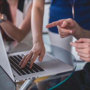 people's hands in front of laptop