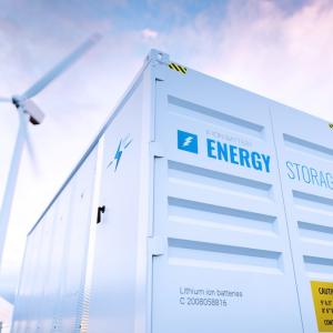 Energy storage container with windmills and solar panels in background