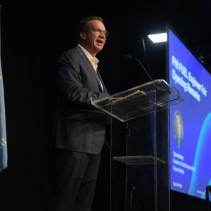 A person speaking at a podium on a stage.