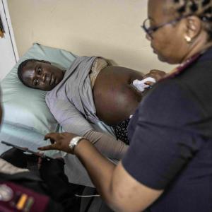 Healthcare professional using an ultrasound on a patient.