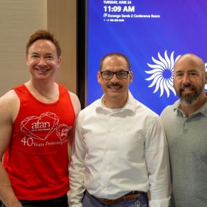 Three people smiling and standing together