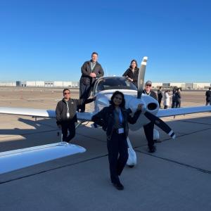 Natalie Villalpando, front, and others around a small aircraft